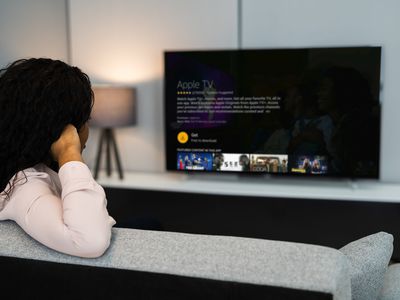 A woman installs Apple TV on a Fire Stick with a TV.