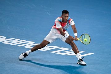 Felix Auger-Aliassime of Canada hits a backhand against Daniil Medvedev of Russia during day 10 of the 2022 Australian Open at Melbourne Park on January 26, 2022 in Melbourne, Australia.