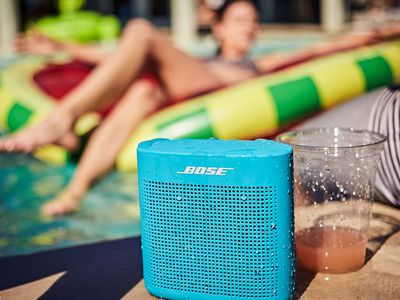 Blue Bose Sounlink next to cups at side of a pool