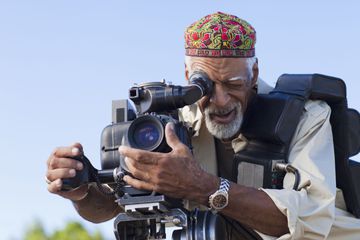 A documentary filmmaker using a camera to capture video.