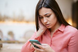 A woman unable to make a call on her phone.