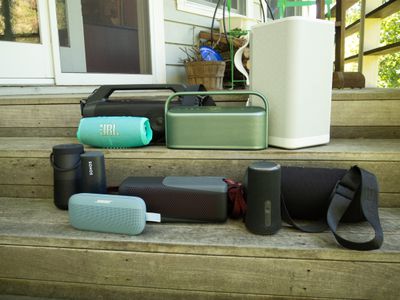 Group of waterproof speakers on wooden steps.