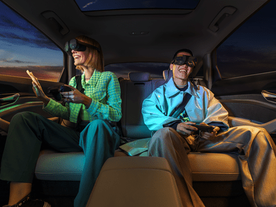 Two people inside a vehicle wearing VR glasses. 